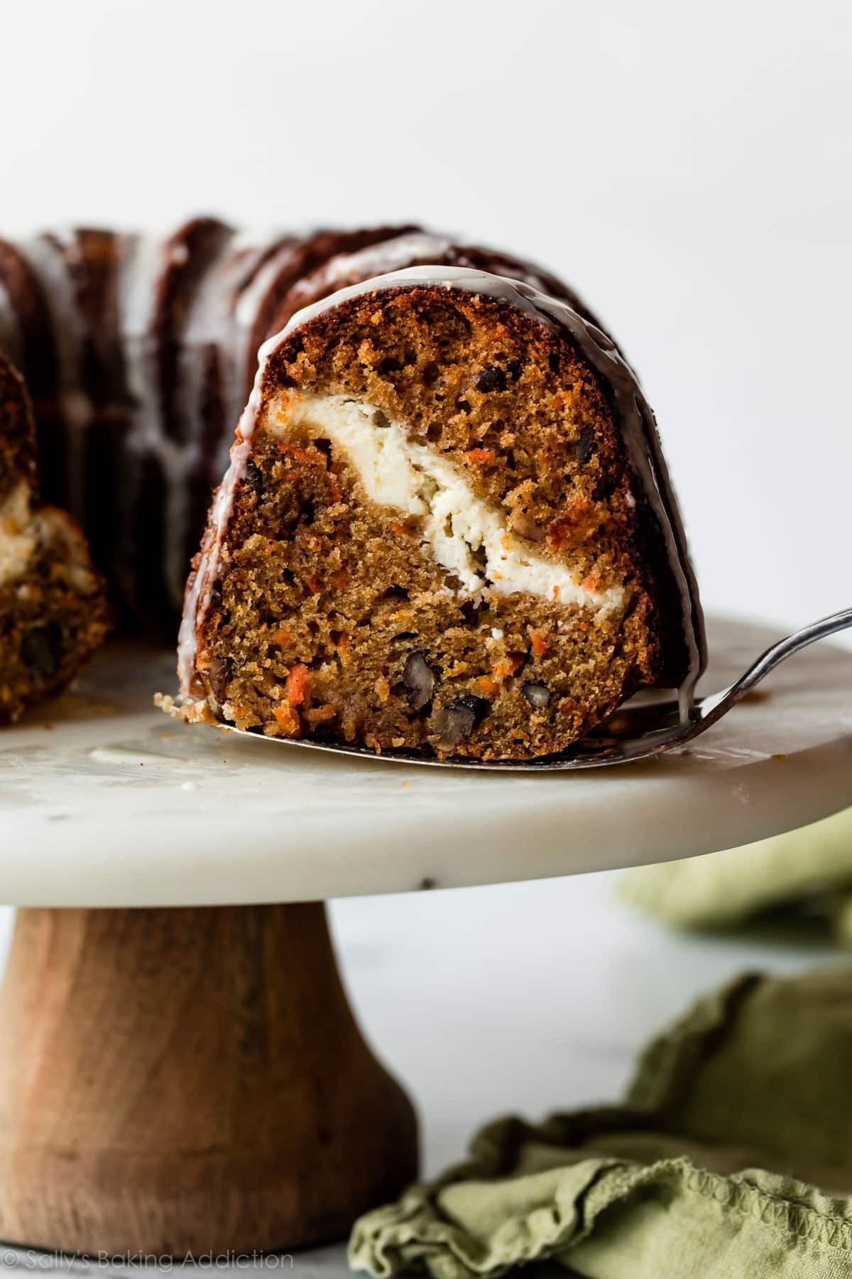 Pie ladle picking a slice of a carrot Bundt cake with cheesecake filling.