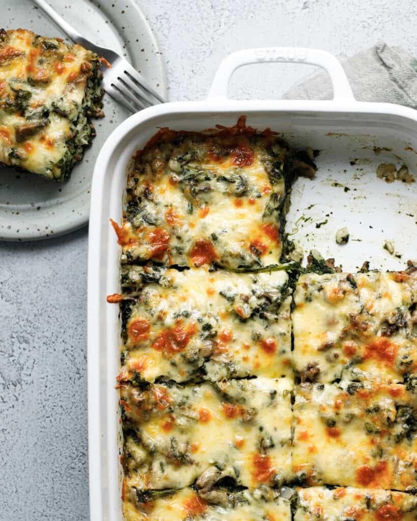 Spinach fandango casserole on a baking dish sliced in square.