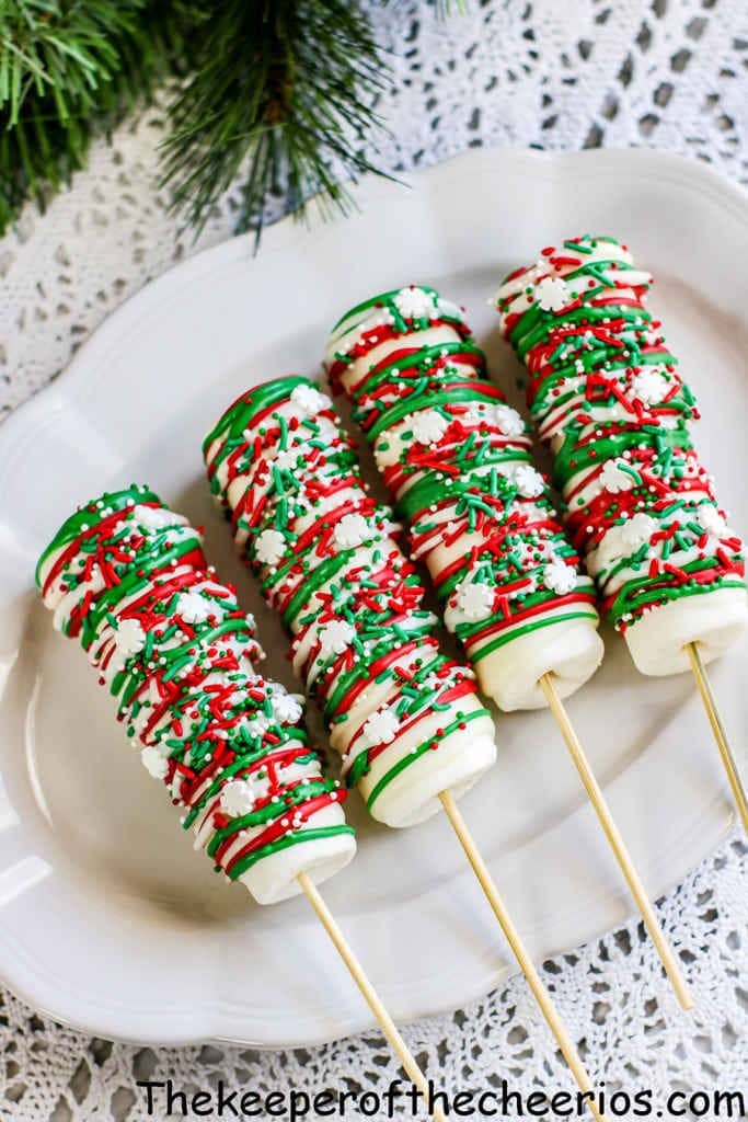 Four Christmas Marshmallow Pops on sticks with sprinkles on top