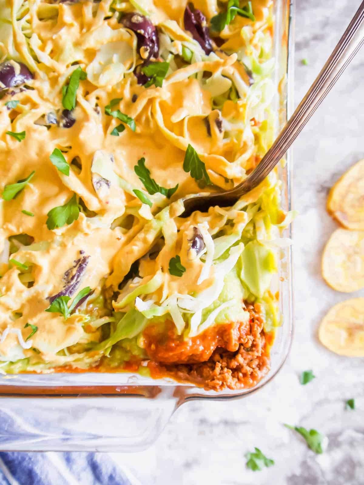 7 layer ground turkey taco dip on a glass casserole dish.