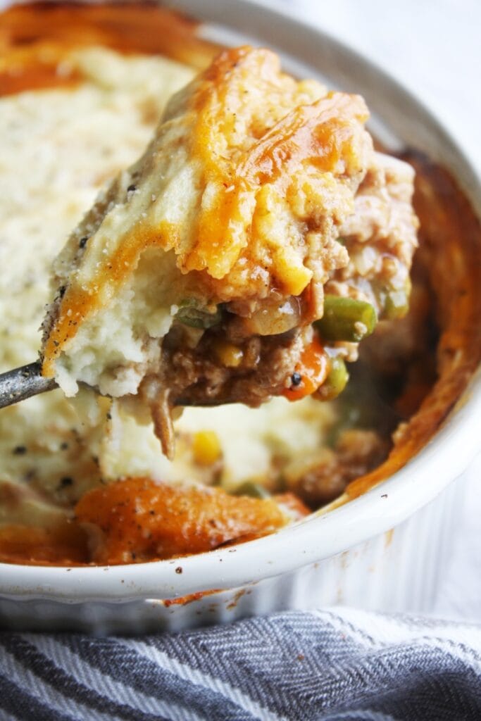 A spoonful of Ground turkey shepherd's pie being lifted from the dish.