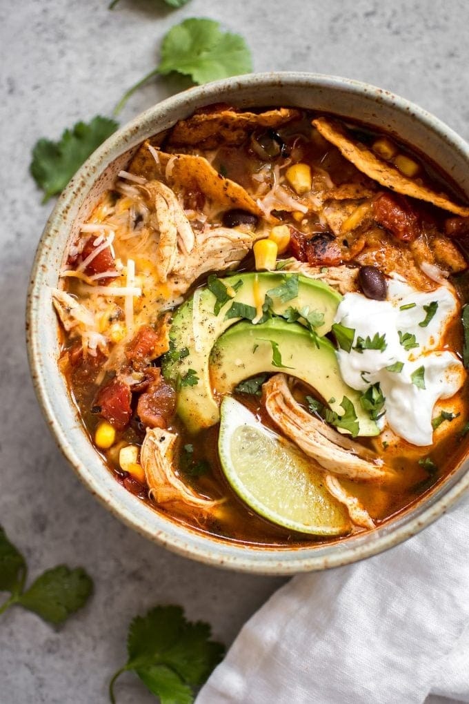 Chicken tortilla soup in a bowl with with chicken, corn, black beans, and fire-roasted tomatoes.