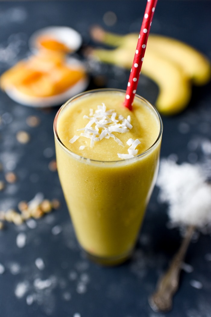 Glass of jackfruit smoothie with red straw.