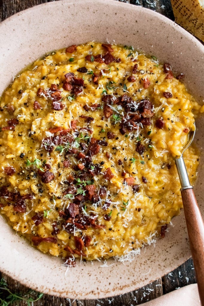 Bowl of pumpkin risotto with bacon and parmesan.