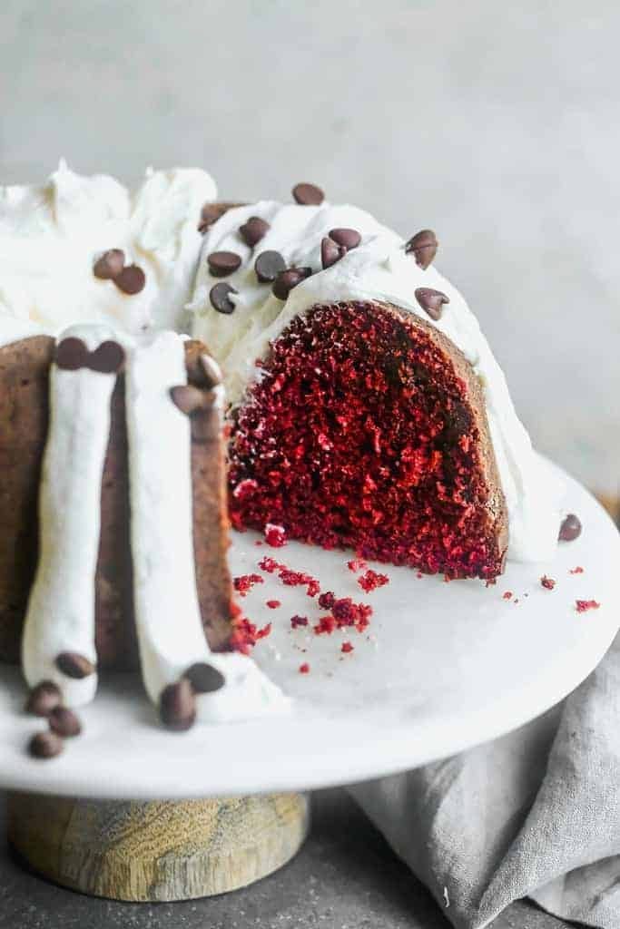 Red velvet Bundt cake with frosting and chocolate chips toppings.