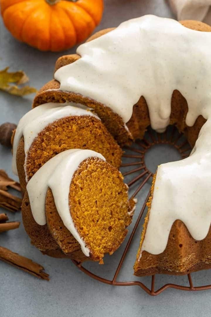 Sliced pumpkin Bundt cake with sugar glaze on top.