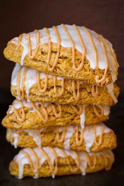 Stack of pumpkin scones with glaze drizzled with caramel syrup.