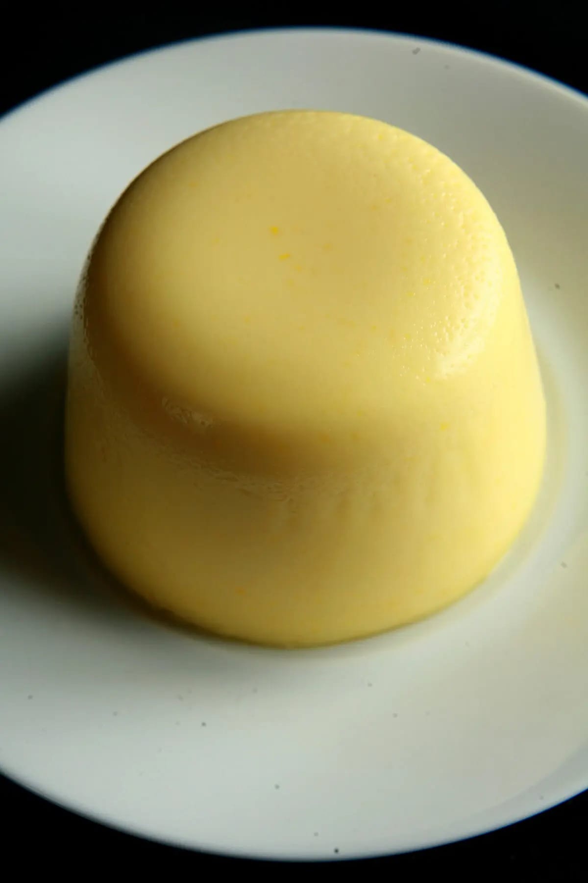 Sweet corn panna cotta on a white plate.