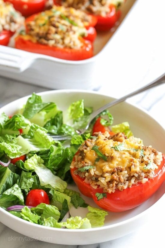 Turkey stuffed bell pepper with chopped lettuce on side.