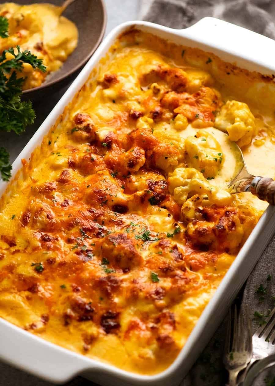 Cheesy cauliflower casserole on a white dish.