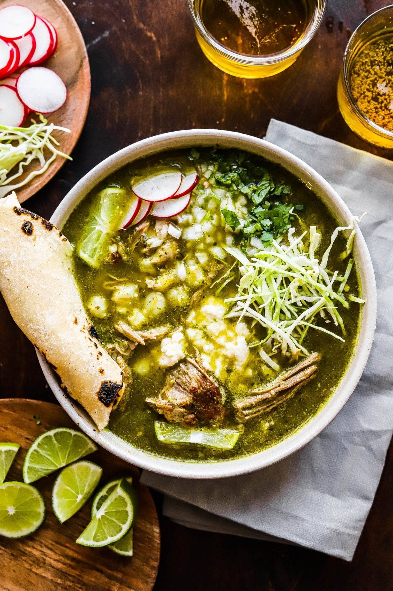 Feta bread dipped on a bowl of Pork Pozole Verde